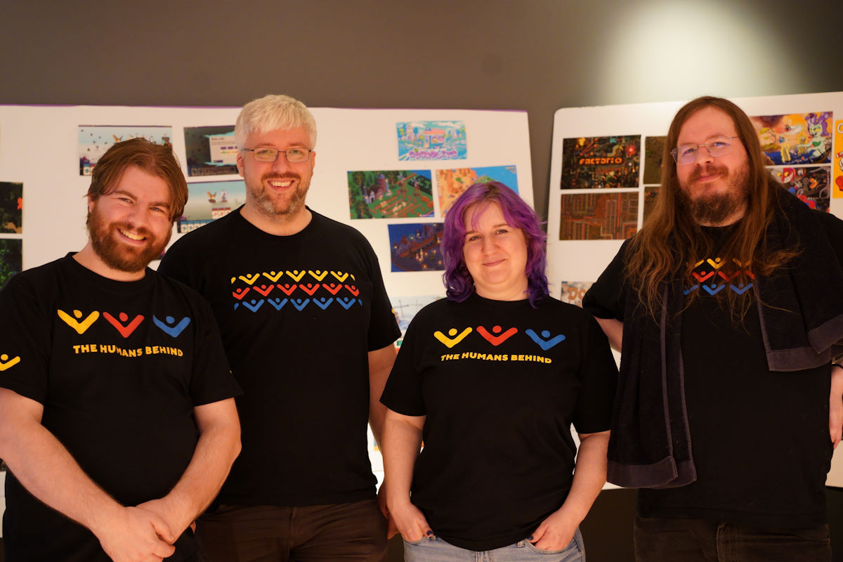 The four volunteers for Game Workers Guild that worked the event. From left to right is, Kristian, myself, Lani who was the organiser of this event and Allan. We are all wearing the Game Workers Guild tshirt which consists of yellow, red and blue abstractions of people putting their hands in the air.