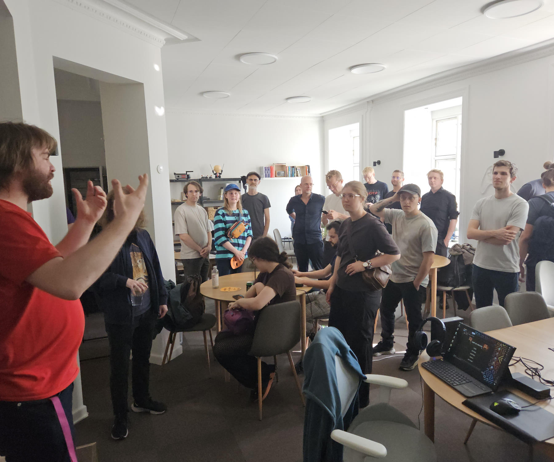 Kristian is in the left side of the image giving a welcome address to a room full of people ready to play games. Alex didn't make it today due to planning conflicts.