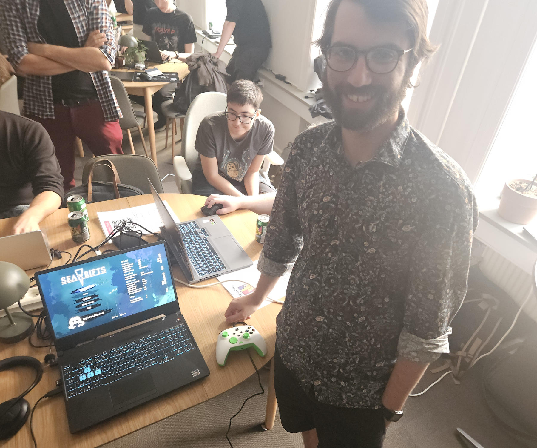 Fergus Doyle standing in front of a laptop with their games title screen in the back.