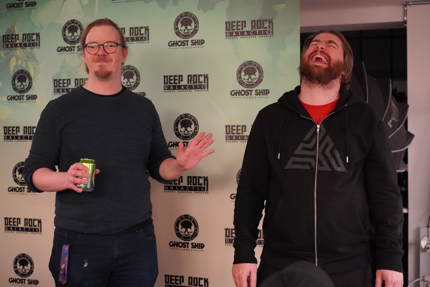 Alex Birke is on the left side of the picture with the Ghost Ship Logo in the background explaining the event and welcoming people while Kristian is laughing on the right at something funny that Alex said.