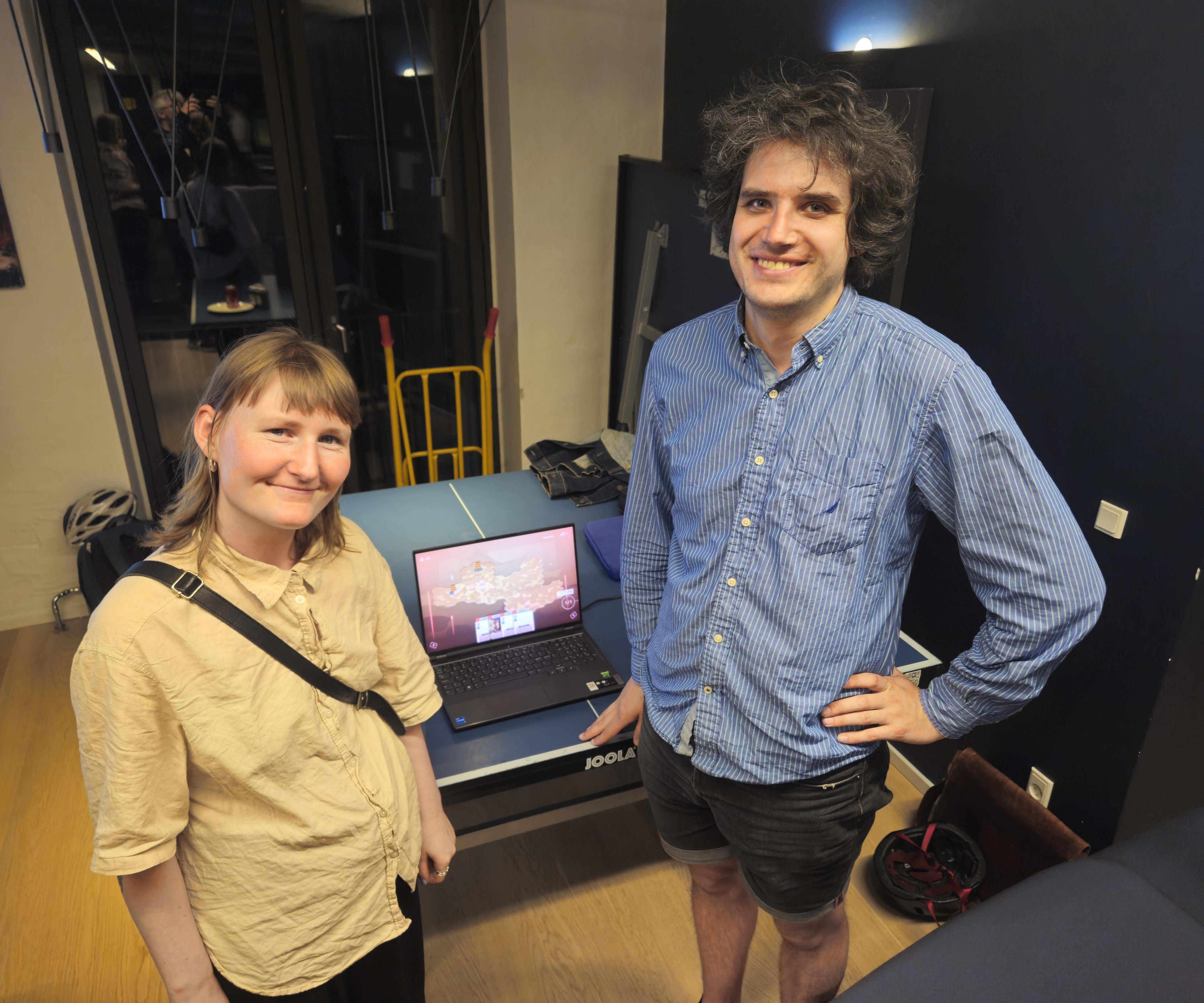 Aia Kragh (Left) and Jonathan Skjøtt (Right) standing in front of a laptop with their game Marc to the Heart.